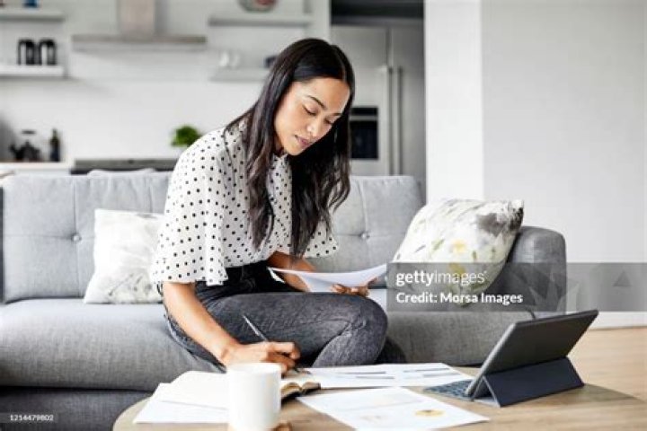 Woman analyzing documents while sitting at home